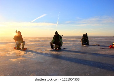 Pärnu, Estonia,  February 17, 2017: Ice Fishing Anglers On Ice And Beautiful Yellow Sunset In Pärnu Bay, Baltic Sea, Estonia