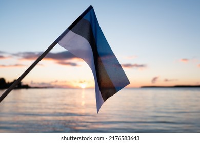 Estonian flag waving at sunset. Flag of Estonia on evening beach background. - Powered by Shutterstock