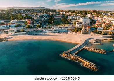 Estoril, Portugal - June 9, 2022: Aerial view of Tamariz Beach with Casino Estoril in the end of the garden and Hotel Palacio on the right