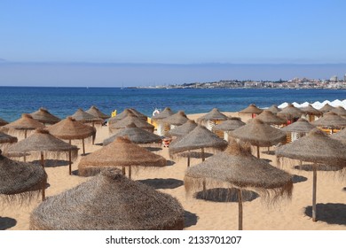 Estoril, Portugal - Tamariz Beach sand and straw parasols.
