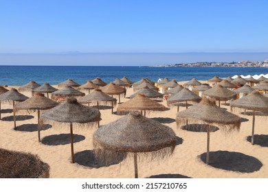 Estoril, Portugal - Tamariz Beach sand and straw parasols.