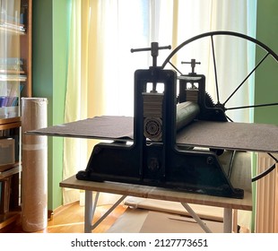 Etching press for printmaking. Linocut, woodcut, etching, monotype, print, embossing stamp. Art equipment in studio. Old ancient engraving machine. Space for text. Art printing step process hand made
