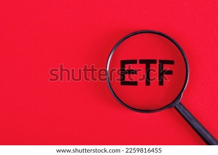 ETF analysis concept. Word through magnifying glass. High quality photo