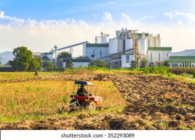 Ethanol Industrial Refinery With Farm Tractors In The Foreground.