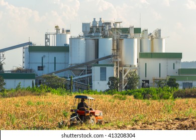 Ethanol Industrial Refinery With Farm Tractors In The Foreground.