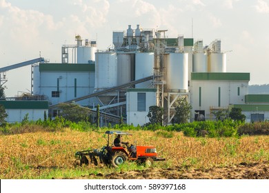 Ethanol Industrial Refinery With Farm Tractors In The Foreground.