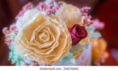 Ethereal, Dreamy, And Soft Focus Close Up View Of Artificial Flowers On Top Of A Wedding Cake.