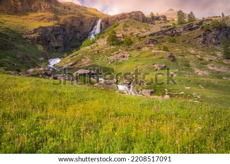 Ethereal waterfall and alpine meadows at springtime, Gran Paradiso Alps, Italy