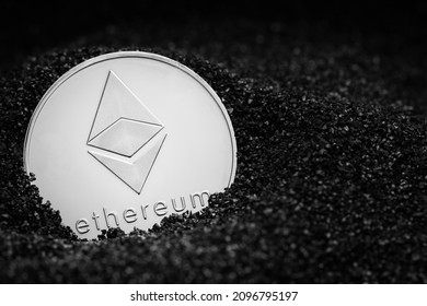 Ethereum coin isolated on black coal background. Ethereum mining. Ethereum closeup. Cryptocurrency mining