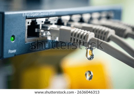 An Ethernet switch with water dripping from a network cable — symbolic representation of data leakage, cyber espionage, and hacker attacks on business networks.