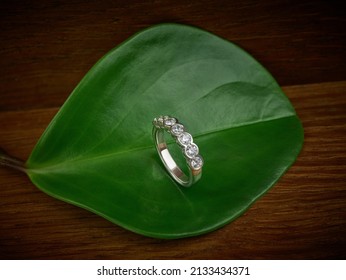 Ethical Lab Grown Diamond Eternity Ring on Green Leaf and Wood Background