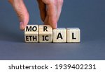 Ethical or moral symbol. Businessman turns wooden cubes and changes the word 