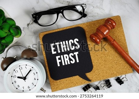 Ethics First text on speech bubble with alarm clock and wooden gavel on marble background
