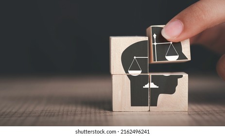 Ethics inside human mind, Business ethics concept. Hand hold ethics inside a head symbols in wooden cubes on dark background with copy space. - Shutterstock ID 2162496241