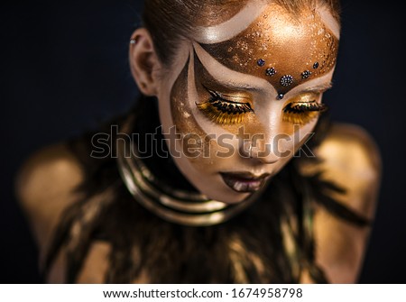 Ethnic body painting. Carnival mask. Golden statue. Keeper of the Sun tribe. Golden body. girl in gold paint. Fantasy makeup