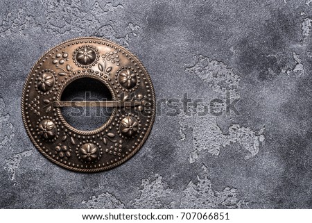 Ethnic brooch on brown background