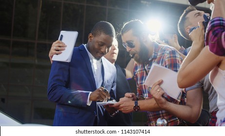 Ethnic celebrity man giving autographs to people on red carpet and makes photos - Shutterstock ID 1143107414