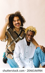 Ethnic Gay Couple Smiling Cheerfully In A Studio. Two Romantic Male Lovers Embracing Each Other Against A Studio Background. Happy LGBTQ+ Couple Posing Confidently In A Studio.