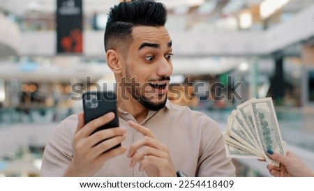 Ethnic Indian man winner male guy browsing betting with phone online bet casino play pay with smartphone app payment service credit easy money amazed shocked get cash prize lottery quick loan banking