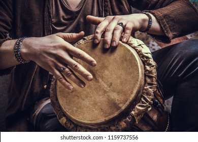 Ethnic percussion musical instrument jembe and male hands. Drummer playing african music