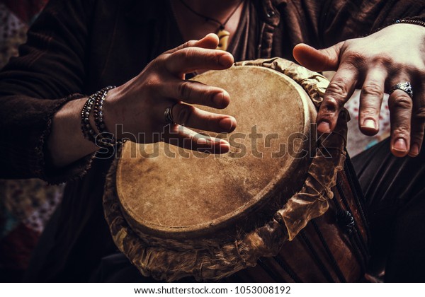 ethnic\
percussion musical instrument jembe and male\
hands