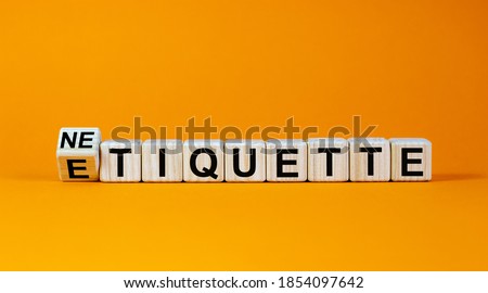 Etiquette or netiquette. Turned cube and changed the word 'etiquette' to 'netiquette'. Beautiful orange background. Business concept. Copy space.