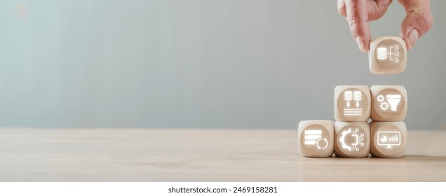 ETL, Extract Transform Load concept, Hand holding wooden block on desk with Extract, Transform and Load icon on virtual screen. - Powered by Shutterstock - Get 15% off with code: PIKWIZARD15