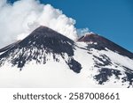 Etna Volcano in Sicily, Italy. The highest active volcano in Europe. Mount Etna Volcano with smoke in bright winter day.