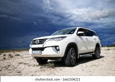 Etosha National Park, Namibia - February 7, 2020: White offroad car Toyota Fortuner in a dry savannah.