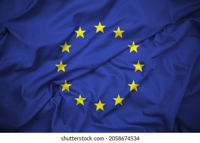 EU Flag, Symbol of the European Union. Twelve Five-Pointed Yellow Stars on a Blue Background. Silk Fabric, Delatiled Texture. High Resolution