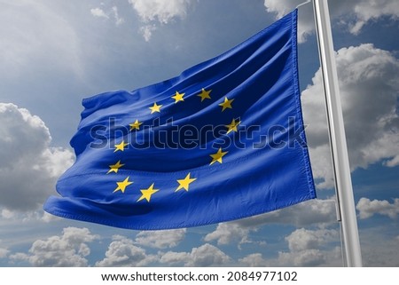 The EU flag is waved in front of the European Parliament building. Brussels, Belgium