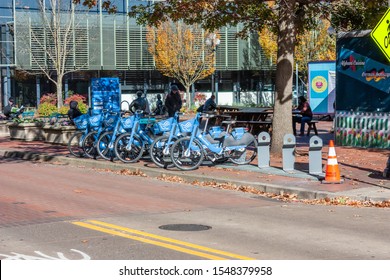 Eugene, OR, 10/29/19: Bike Share Rack in front of Kesey Plaza with People Relaxing Near Food Carts Downtown