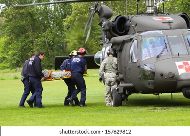 EUGENE, OREGON, USAÂ?Â? May 2, 2012: In Eugene, OR The Local Emergency Services And National Guard Work In A Disaster Drill. The Firemen Carry An Injured Person On A Backboard To The Helicopter. 