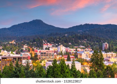 Eugene, Oregon, USA downtown cityscape and mountains at dusk.