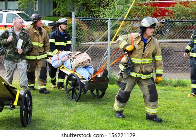 Eugene, Oregon, USA Â?Â? May 2, 2012: Eugene, OR Emergency Services And National Guard Work In A Disaster Response Drill. The Unidentified Firemen Are Transporting Unidentified Injured To Landing Zone.