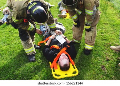 Eugene, Oregon, USA  May 2, 2012: In Eugene, OR The Local Emergency Services And National Guard Work Together In A Disaster Response Drill. The Unidentified Firemen Are Looking At The Injury Card. 