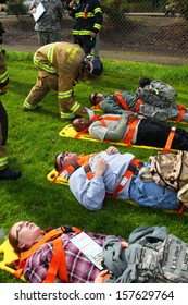 EUGENE, OREGON USA Â?Â? May 2, 2012: Eugene, OR The Local Emergency Services And National Guard Work Together In A Disaster Drill. The Firemen Are Reviewing The Injury Status Cards On The Injured.