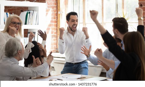 Euphoric excited business team celebrate corporate victory together in office, happy overjoyed professionals group rejoice company victory, teamwork success win triumph concept at conference table - Shutterstock ID 1437231776