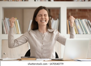 Euphoric female student celebrating received high score evaluation tests results or passed university session. Excited young girl sitting at classroom, got pleasant email, reading win notification. - Powered by Shutterstock