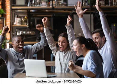 Euphoric overjoyed diverse friends screaming celebrating sport game victory goal score watching match online game on laptop sit at cafe table, happy multiracial fans supporters cheering winning team - Powered by Shutterstock