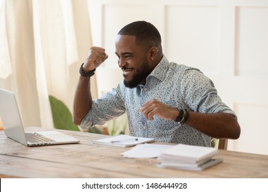 Euphoric Young Black Man Celebrating Online Lottery Win, Excellent Educational Online Courses Tests Results, Successful Qualification Training, Getting Remote Dream Work, Received High Paid Job Offer.