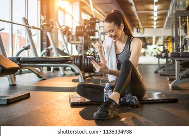 Euphoric Young Woman Reading Good News On Mobile Phone During Rest In Fitness Workout At Gym