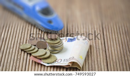 Euro banknote and coins on brown wooden plank. , use as Business and finance concept or Investing in Mass Transit and Military