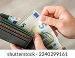 Euro banknote in wallet in hands of a woman, close up. Buying things and paying for them, exchange, small money
