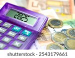 Euro banknotes and coins, calculator and forecast for finances in 2025