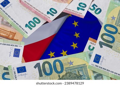 Euro banknotes lying around the flags of Poland and the European Union displayed on a smartphone, concept of cash flow, financing, European funds and contribution to the European budget