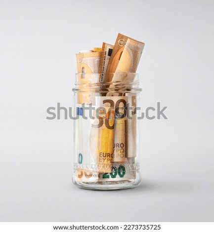 Euro bills in glass jar on white background. Saving money concept