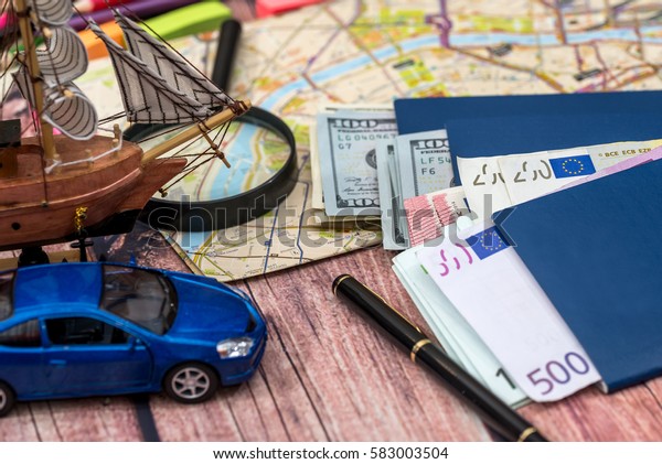 euro bills for a travel, car,\
maps, passport, and other stuff for adventure on the\
table.
