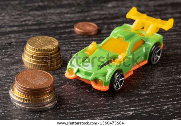 Euro car\
and euro toy on dark wooden background. The concept of financial\
costs for the repair of the\
vehicle