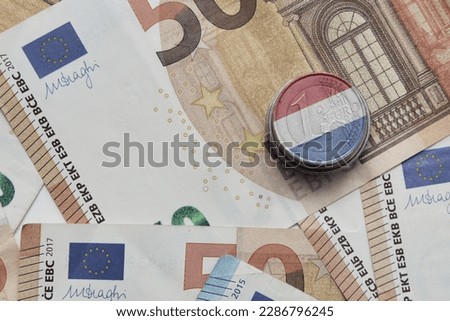 euro coin with national colorful flag of netherlands on the euro money banknotes background